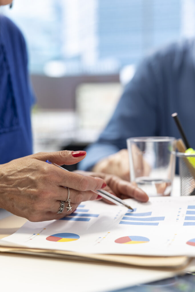 Senior people in a modern office analyzing retirement plans with a financial broker, looking into various pension options. Covering savings and family expenses with future investments.